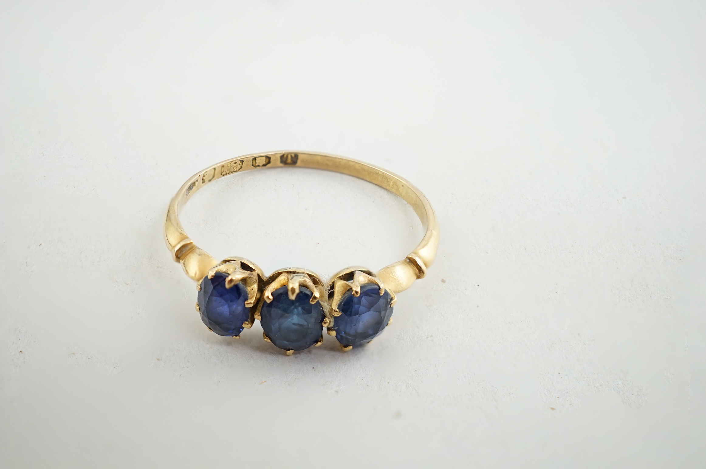 A late Victorian 18ct gold and three stone oval cut sapphire set ring, size P/Q, gross weight 1.9 grams. Condition - fair